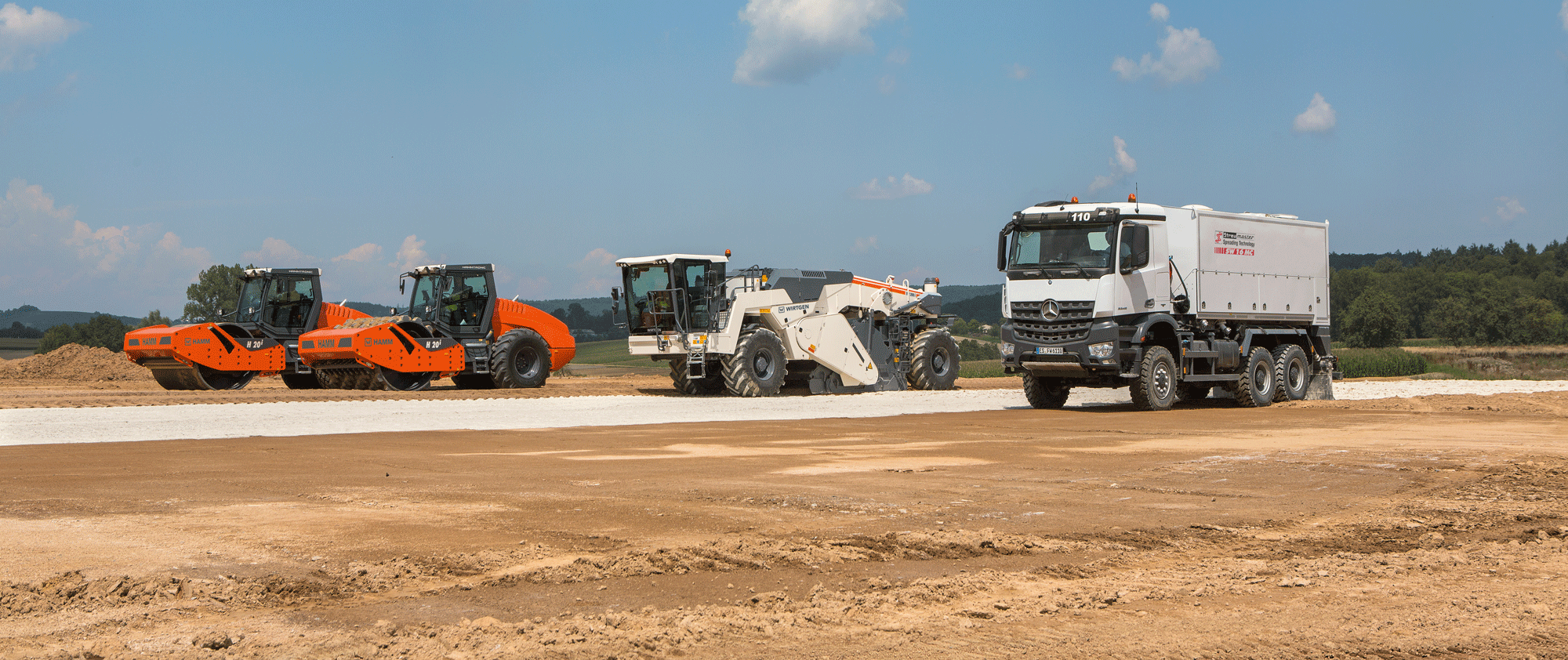 Abwicklung wie am Schnürchen … Der Streumaster SW 16 MC streut den Kalk vor, der WIRTGEN WR 200i arbeitet das Bindemittel homogen in den Boden ein und gleich dahinter verdichten die beiden HAMM H 20i den Boden.