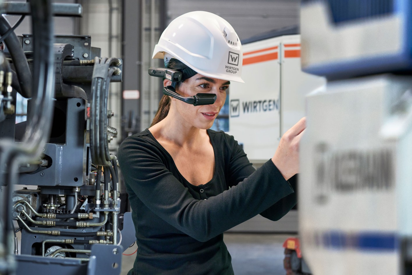 A female mechanic wearing Expert-Assist VR glasses while working on a machine